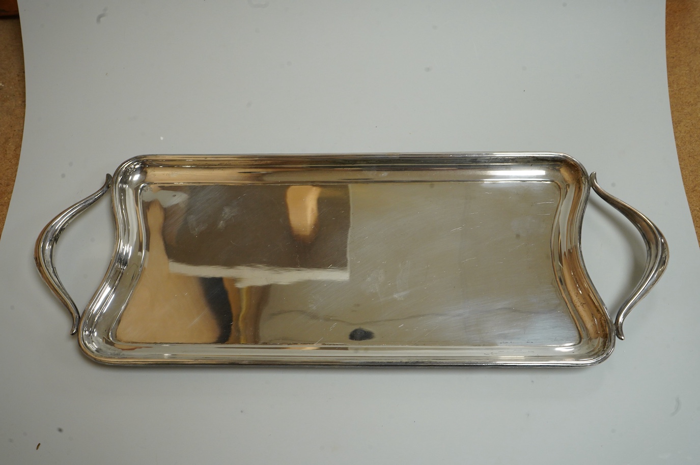 A George V silver sauceboat by Mappin & Webb, Birmingham, 1933, length 16.2cm, together with a silver salt and spoon, with blue glass liner, a silver pepperette, a pair of silver sugar tongs and a Spanish white metal two